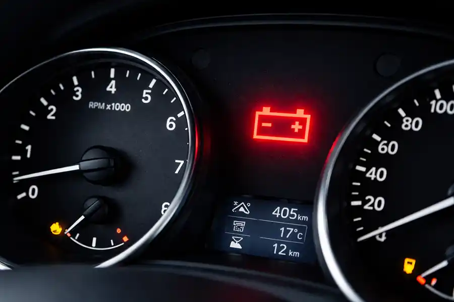 Image of a vehicle dashboard with the battery warning light on.